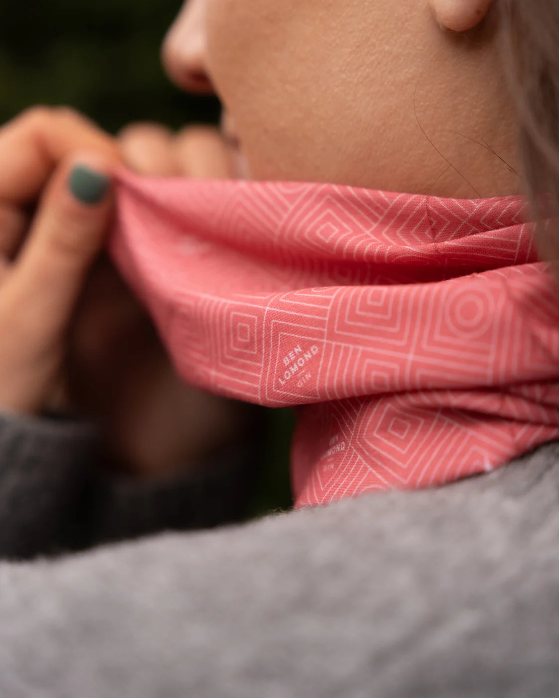 Person wearing a pink patterned headscarf with a blurred background
