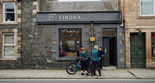 People standing outside a building with 'FINDRA' branding on a street.