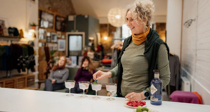Woman preparing drinks in a home setting with friends in the background