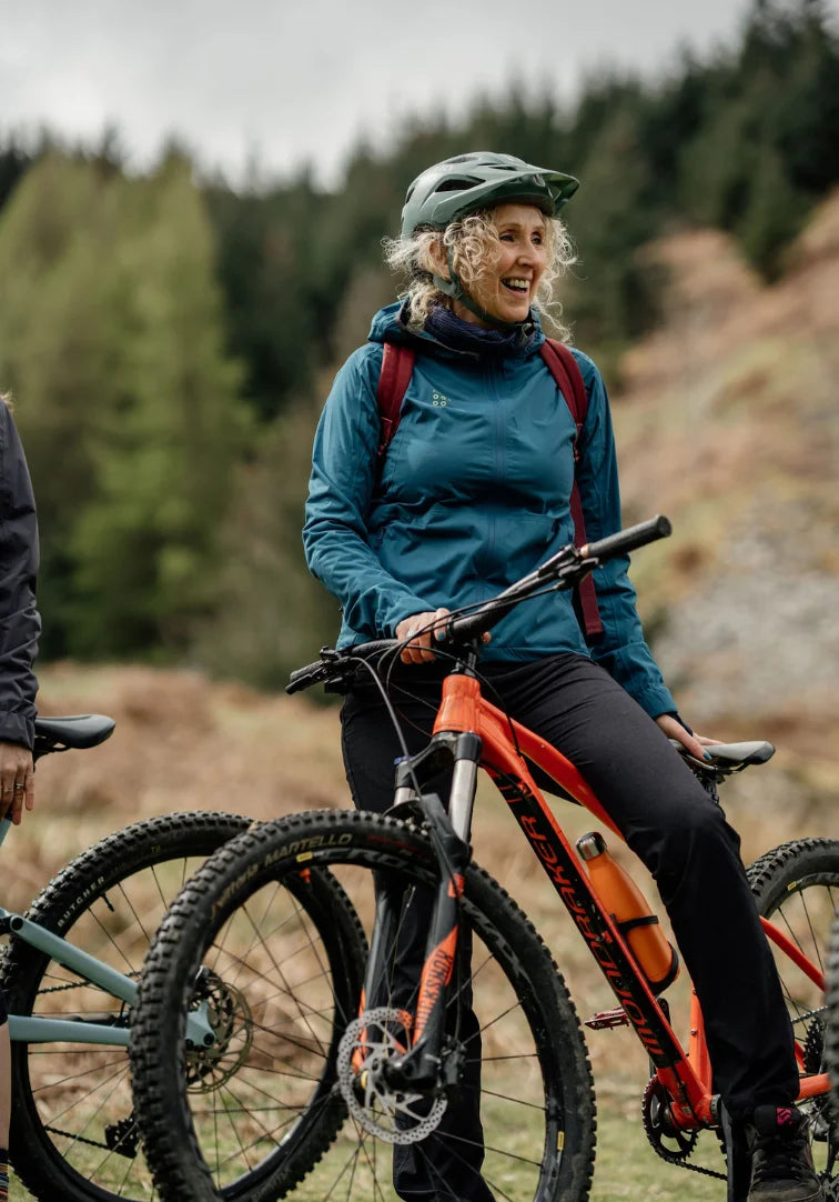 Woman with a bicycle in a forested area