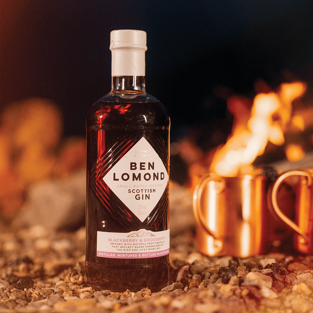 Bottle of Ben Lomond Scottish Gin with a fireplace and copper mugs in the background