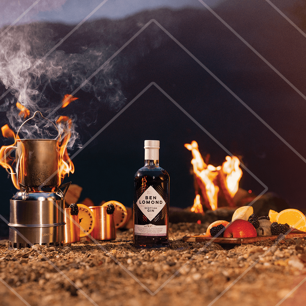 Ben Lomond gin bottle with a campfire and food in the background