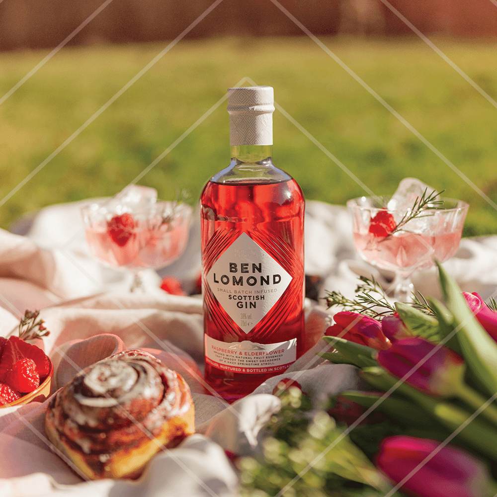 Bottle of Ben Lomond Scottish Gin with a picnic setup including flowers and pastries.