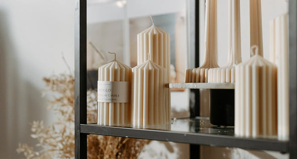 Decorative candles on a shelf with a mirror reflection