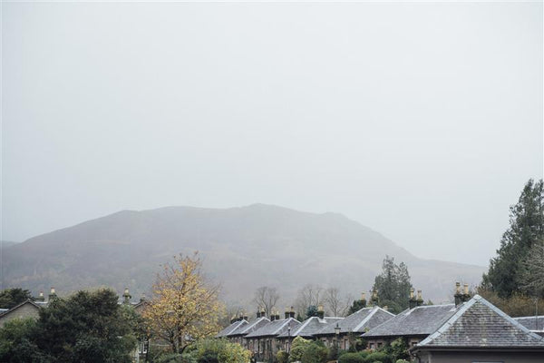 Houses with snow on roofs against a foggy mountain background