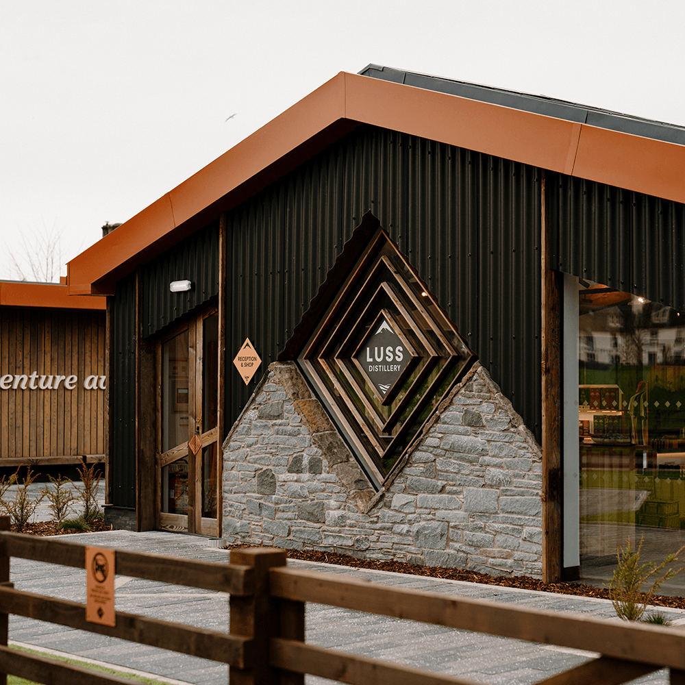 Modern building with a geometric design on the wall, featuring the brand 'Luss Distillery'.